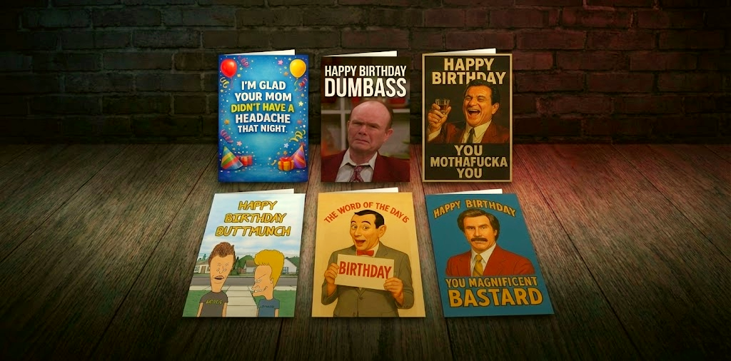 Collection of humorous birthday cards on a wooden surface with a brick wall background.
