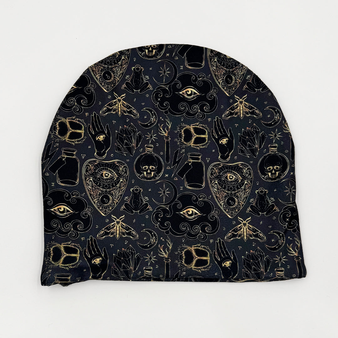 Black beanie with gold and white symbols on a white background