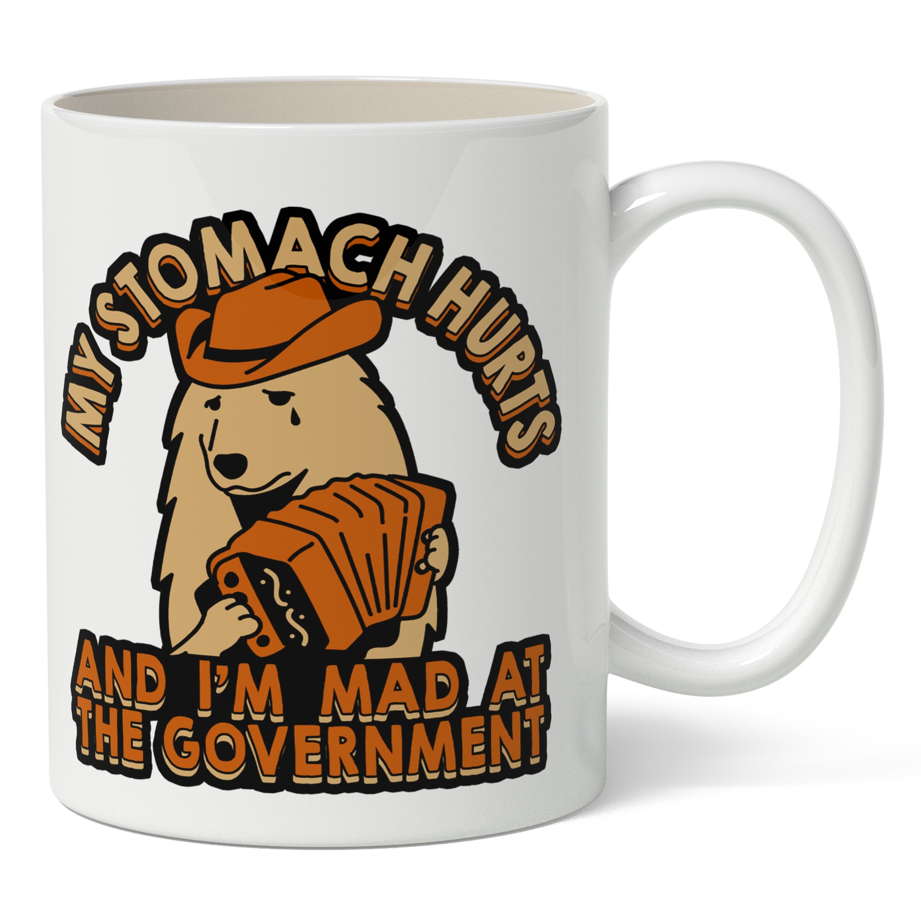 A white ceramic mug with a printed design featuring a cartoon dog character, an accordion, and the text 'MY STOMACH HURTS AND I'M MAD AT THE GOVERNMENT!'.