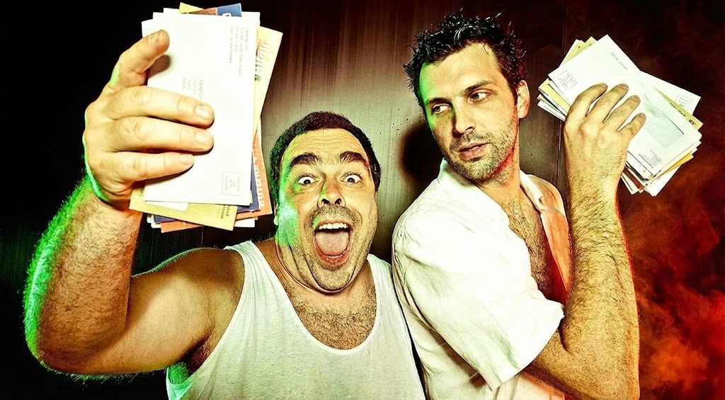 Two men holding stacks of mail with a dark background