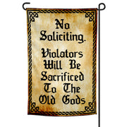 A garden flag with a beige background and black text that reads 'No Soliciting. Violators Will Be Sacrificed To The Old Gods'.