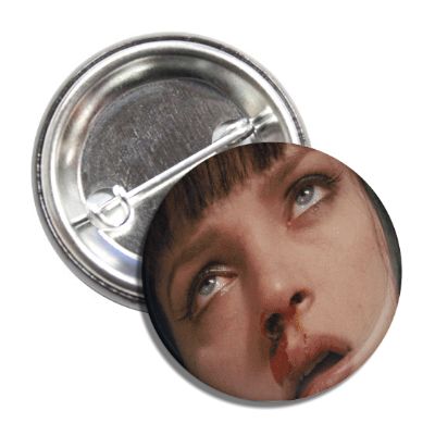 A round metal pin badge featuring an image of a character from the movie 'Pulp Fiction'.